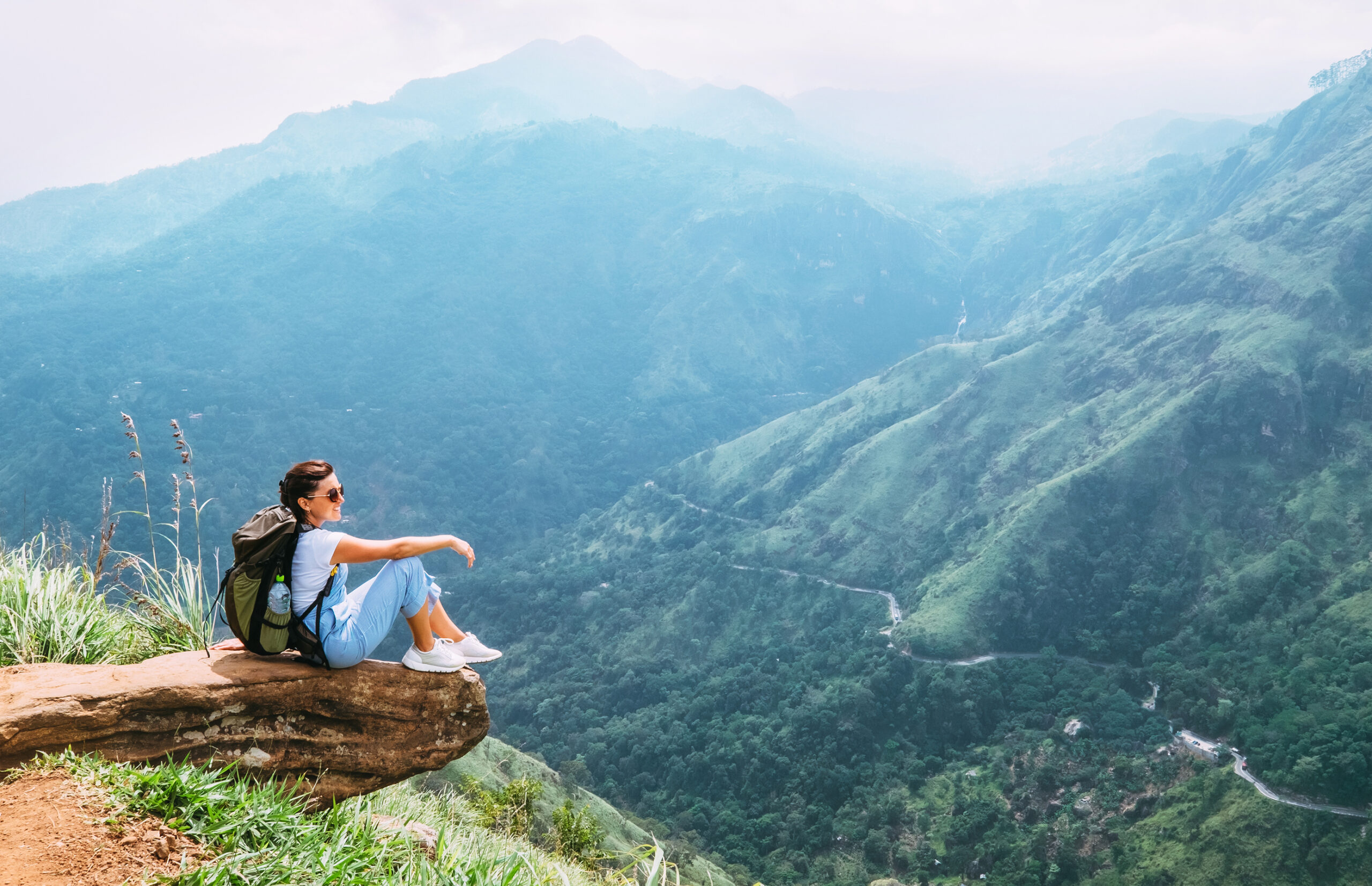 dreamstime_l_119582553 Woman sitting on top of a mountain